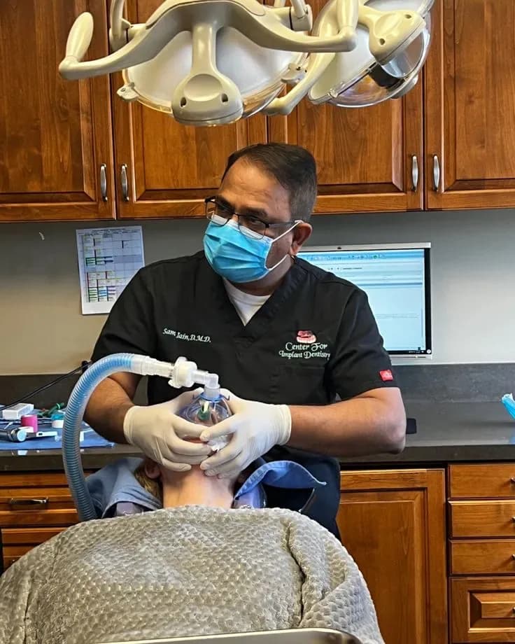 Dr. Sam Jain placing an implant with the patient comfortable under IV sedation