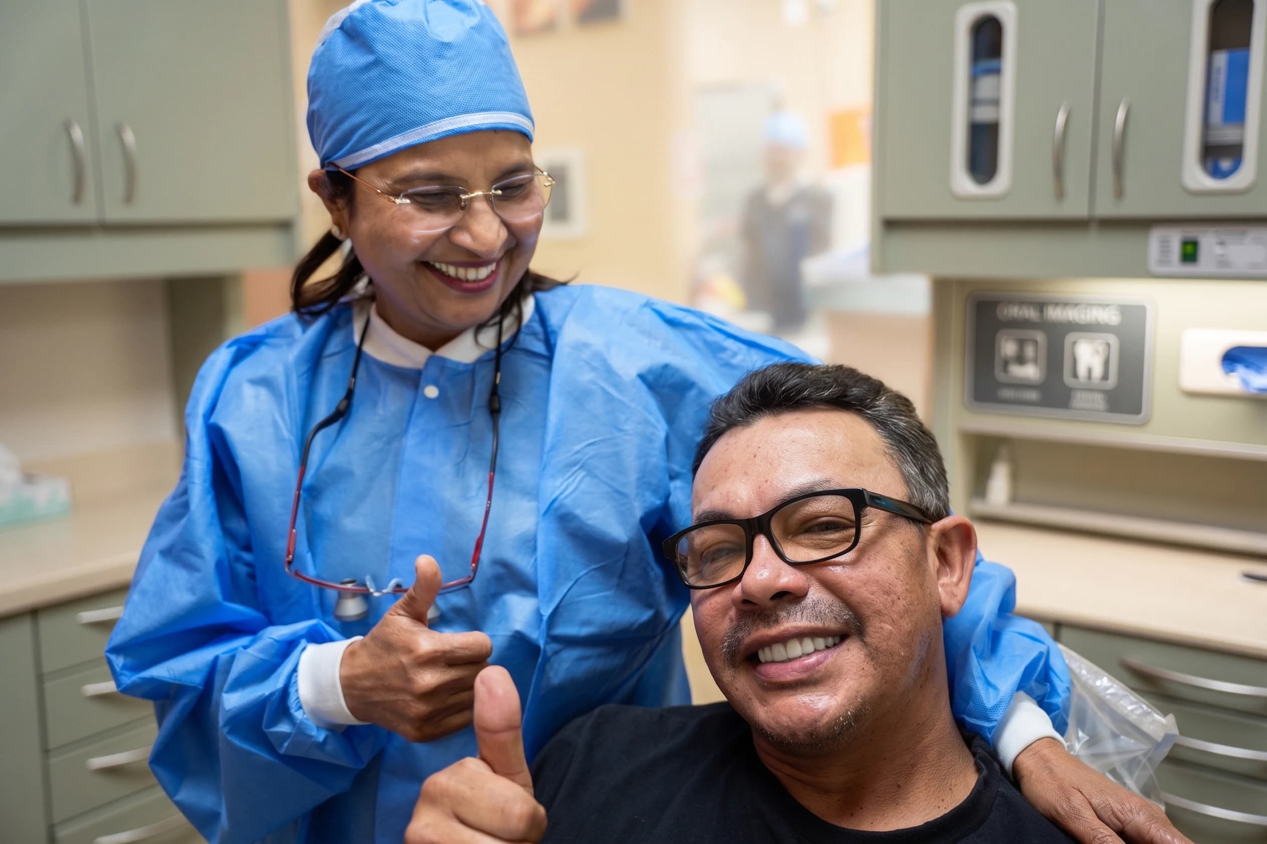 A patient and his surgeon giving a thumbs up after treatment