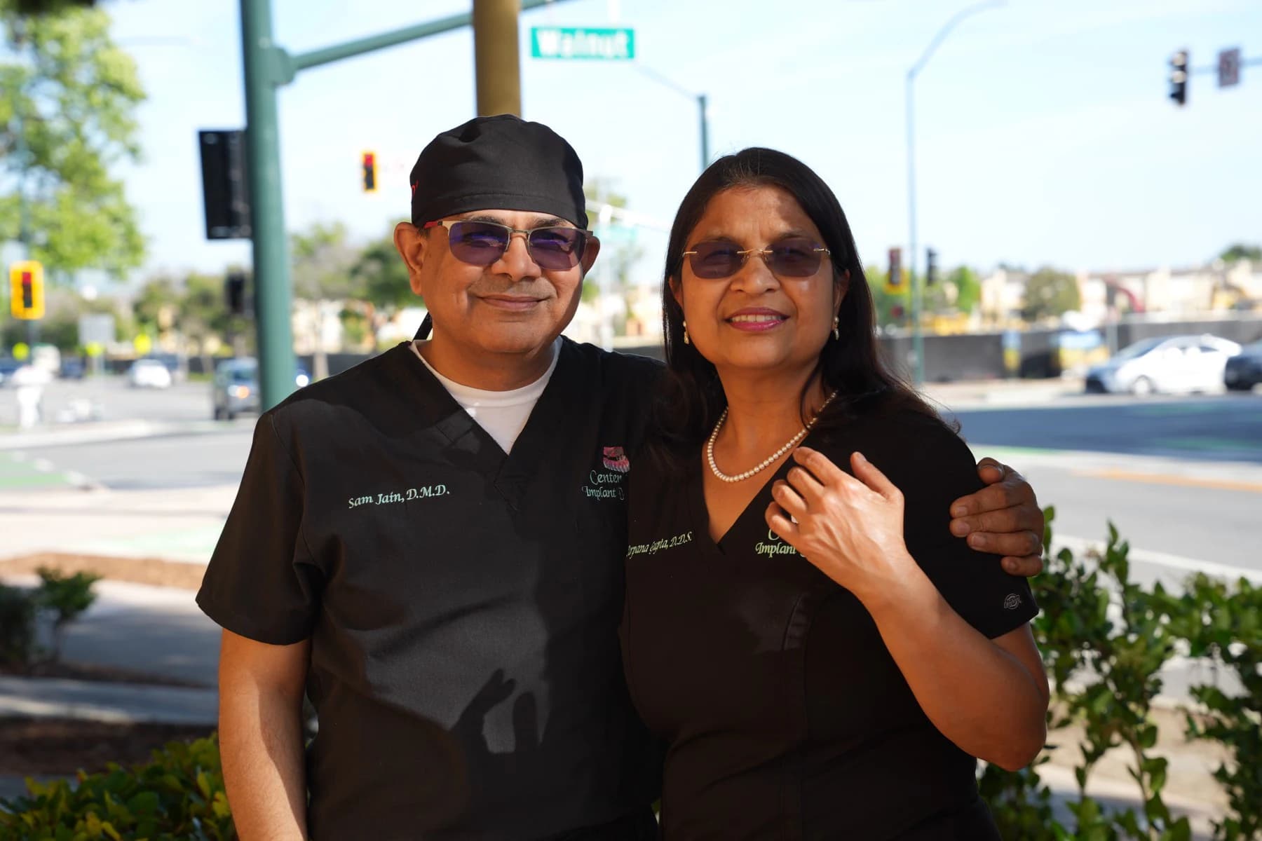 Dr. Sam Jain and Dr. Arpana Gupta in their scrubs outside the practice on Walnut Ave in Fremont