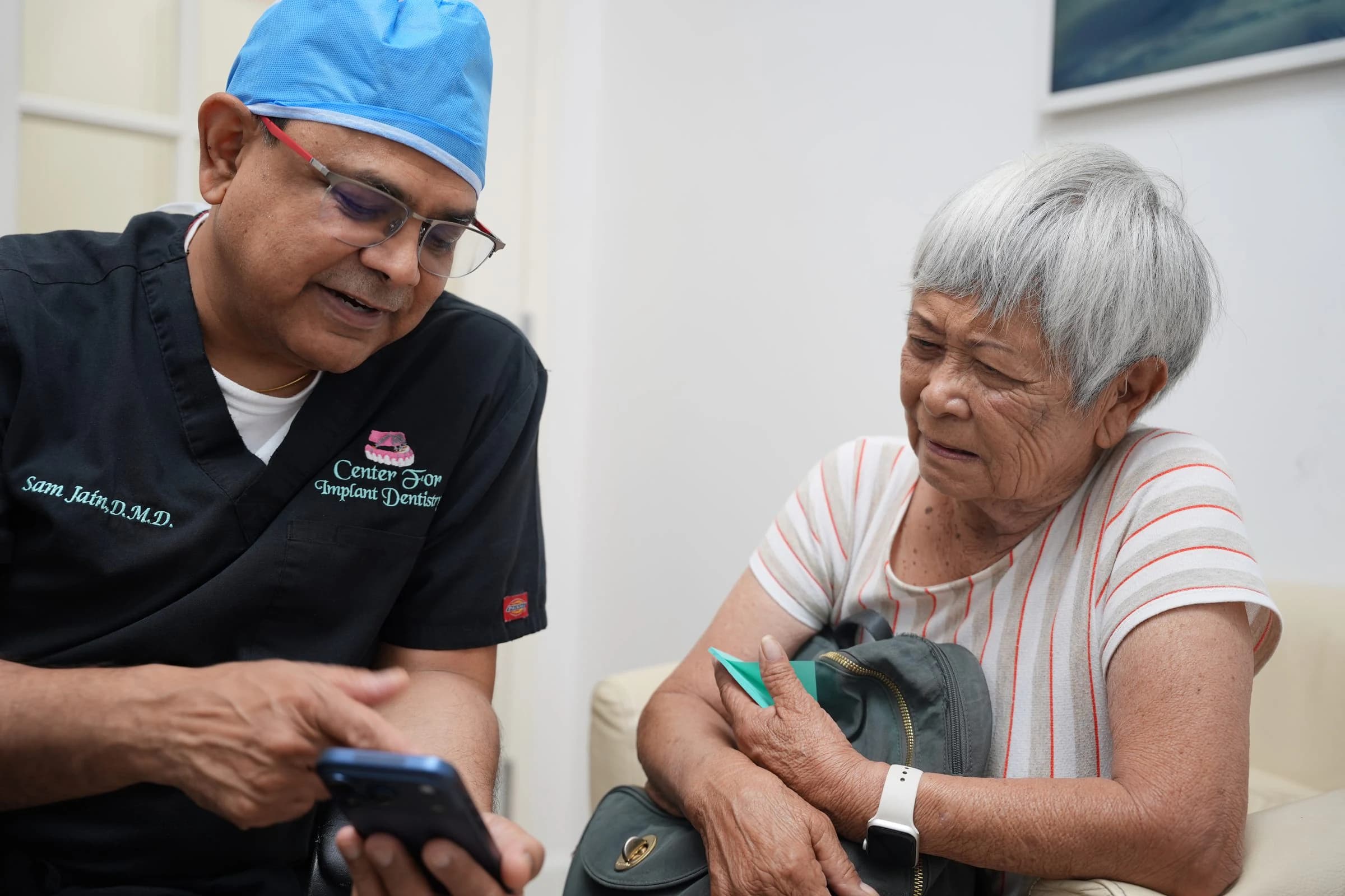 Dr. Sam Jain reviewing a treatment plan with a senior patient