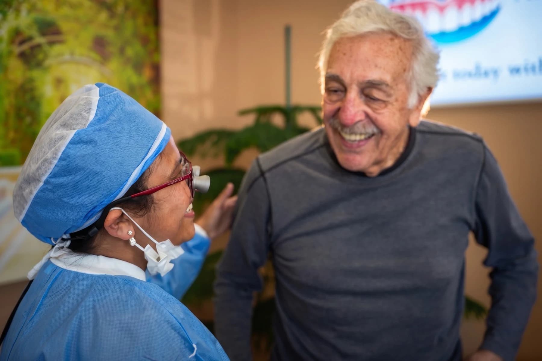 A patient and a surgical assistant laughing together after care