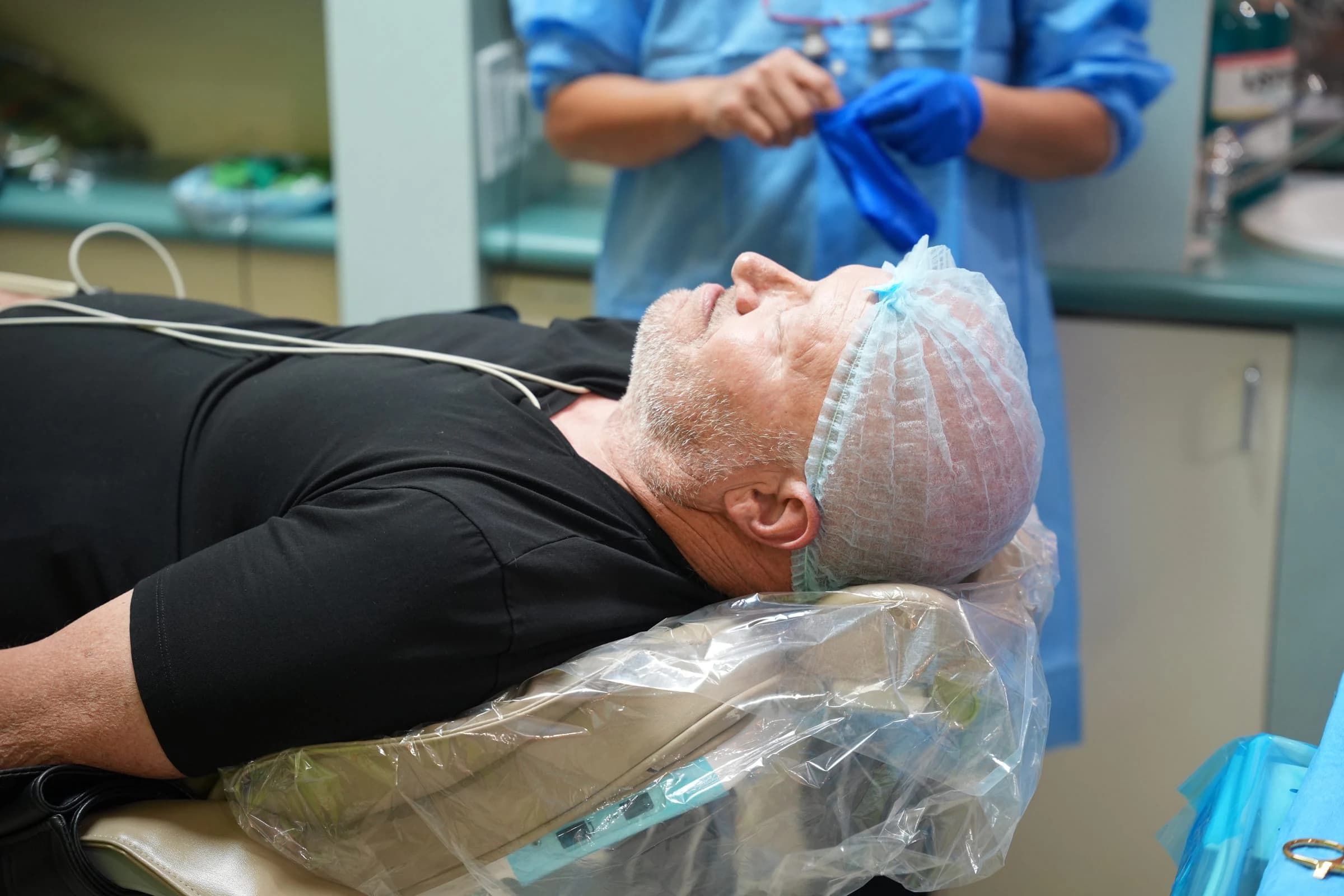 A patient prepared for dental implant surgery with the clinical team nearby