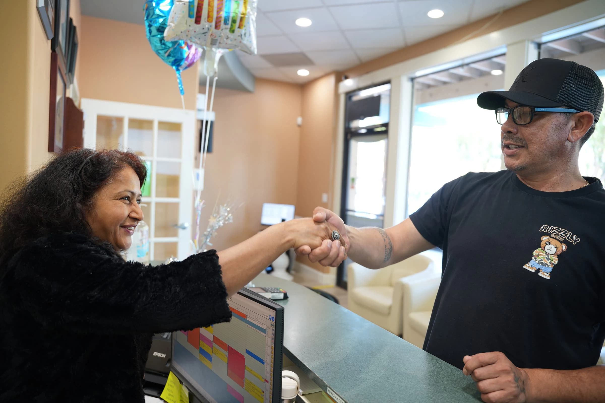 Patient from Palo Alto, CA shaking hands with the team at the front desk